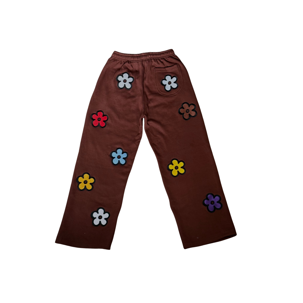 Brown pants with colorful flower appliqués on a white background
